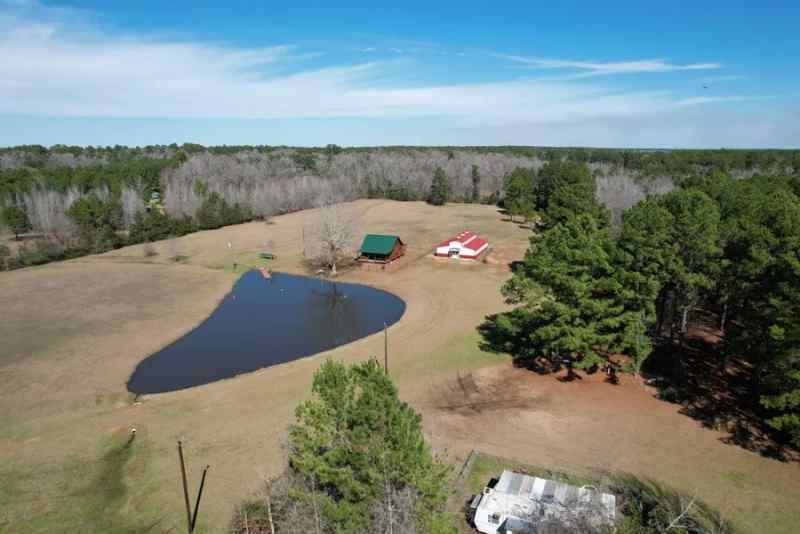 25 acres w/ cabin, metal barn, pond in Crockett TX